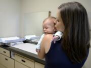 Sarah MacDonald of Camas shares a quiet moment with her 2-month-old son, River, while waiting to see Dr. Jennifer Lyons at The Vancouver Clinic Columbia Tech Center on Thursday afternoon.