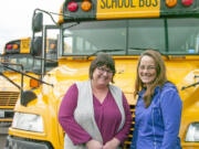 Judit Prihoda, left, and Ileen Neibert, right, pose for a photo in front of Neibert's bus at the Camas School District's transportation headquarters.