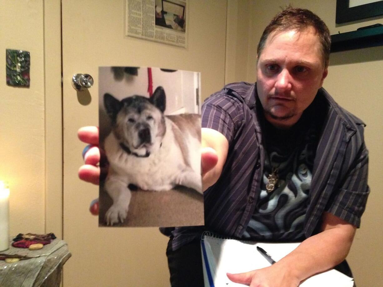 Sue Vorenberg/The Columbian
Psychic medium Seth Michael holds out a picture of Brittny Houghton's dog Bernie, which died recently. He said Bernie's spirit was lingering near her and still interacting with Houghton's other animals.