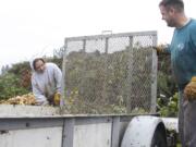 Kandi White of Hockinson and her husband, Travis, finish unloading yard debris Sunday at H &amp; H Wood Recyclers in the Orchards area.