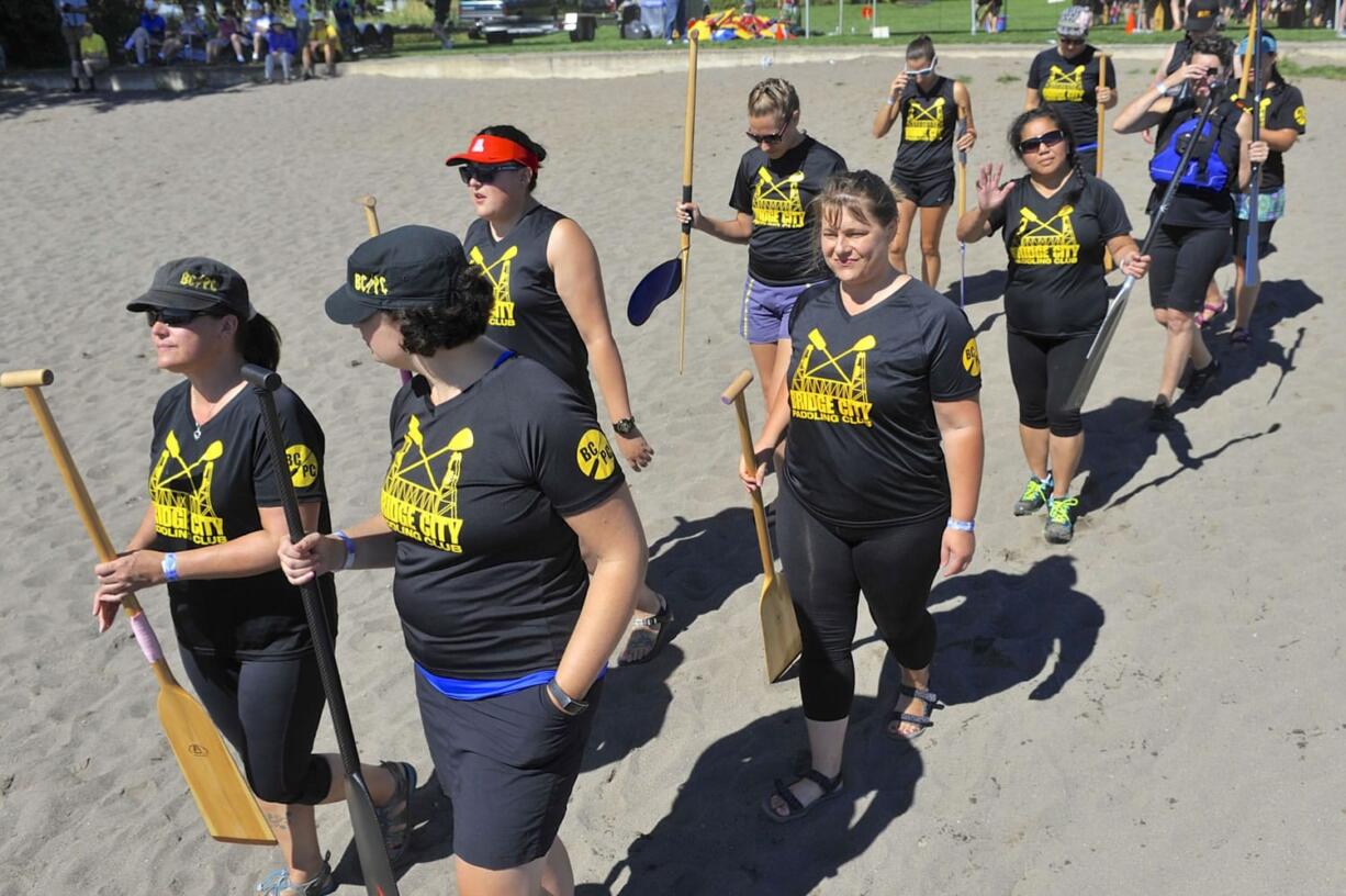 Members of the 'Bridge City' team from Portland head down to their boat at the Pacific Dragon Boat Association Championship races at Vancouver Lake in Vancouver  Wa., Saturday August 1, 2015.