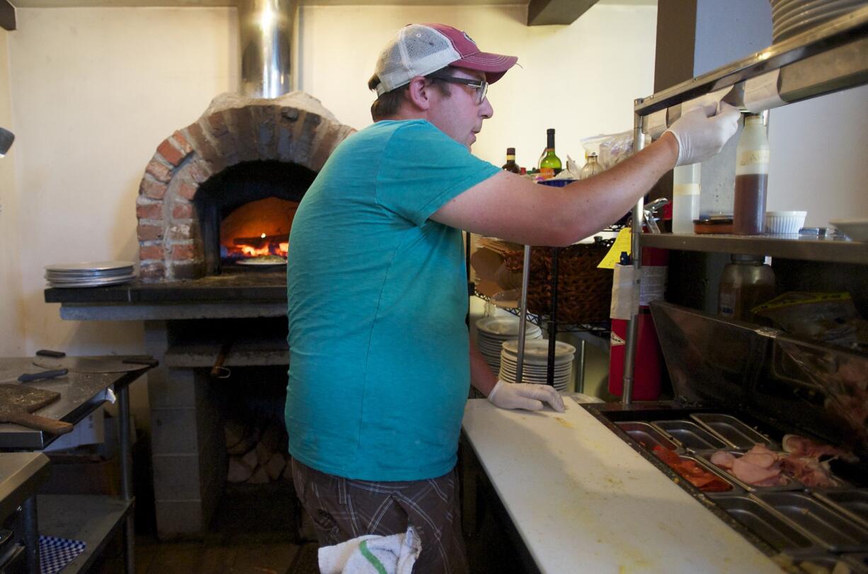 Jeremy Brown, owner of Rusty Grape Vineyard, prepares food for a wine tasting on July 26, 2013.