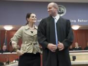 Derek Vanderwood dons a judge's robe for the first time, assisted by his wife Allison, at his swearing-in ceremony to become a judge in Clark County Superior Court.