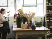 Longtime employee Gretchen Van De Water assembles a floral arrangement for a funeral Thursday at Luepke Florist.