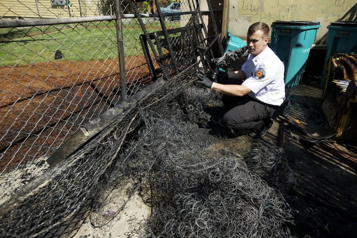 Deputy Fire Marshal Zane Norris investigates a fire near a dumpsters at an apartment complex.
