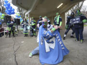 Fans of the Seattle Seahawks gather Saturday in Esther Short Park for a 12th man rally in advance of Sunday's Super Bowl game against the New England Patriots. Top: Travis Trombley shows his Seahawks spirit through his hairstyle at a rally in downtown Vancouver.