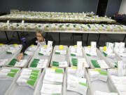 Elections worker Nancy Bergman counts empty envelopes that have already had the ballots inside them removed at the Clark County Elections office on Monday.