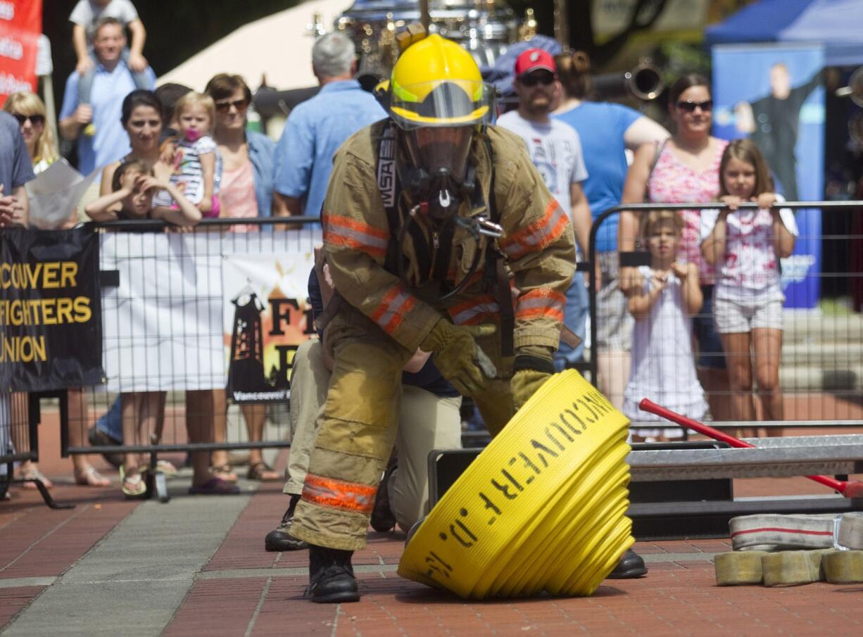 Tyler Dillmon demonstrates his strength and skills as quickly as he can during Saturday's Fire in the Park, which featured friendly contests between firefighters and also educated visitors of all ages about fire safety, first aid and lots more.