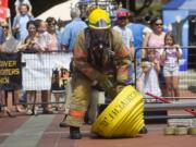 Tyler Dillmon demonstrates his strength and skills as quickly as he can during Saturday's Fire in the Park, which featured friendly contests between firefighters and also educated visitors of all ages about fire safety, first aid and lots more.