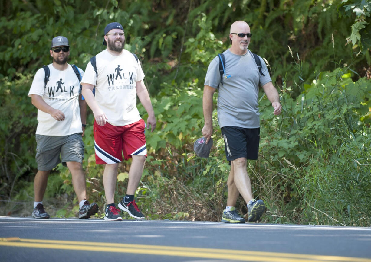 Camas High School teachers Tyler Morgan, left, Joe Farland and Sam Greene, right, walked from Vancouver to Woodland on Monday.