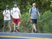 Camas High School teachers Tyler Morgan, left, Joe Farland and Sam Greene, right, walked from Vancouver to Woodland on Monday.