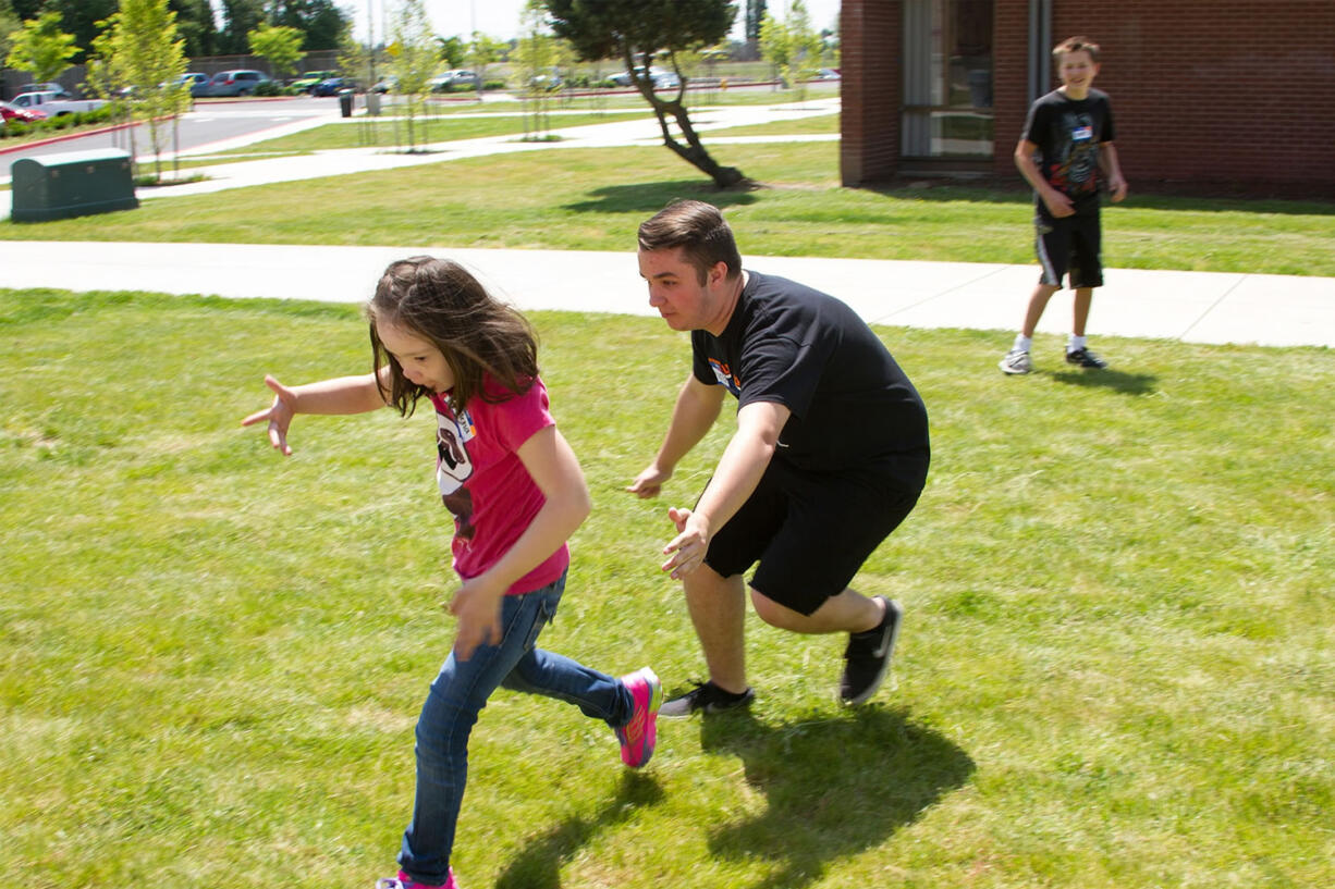 Ridgefield: Carter Allen, a junior at Ridgefield High School, plays tag with the students at the school's field day, which Ridgefield's leadership class organized for 90-plus special education and life skills students from other schools.