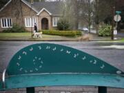 A man walks his dog past a public bench made by a local resident in Arnada.