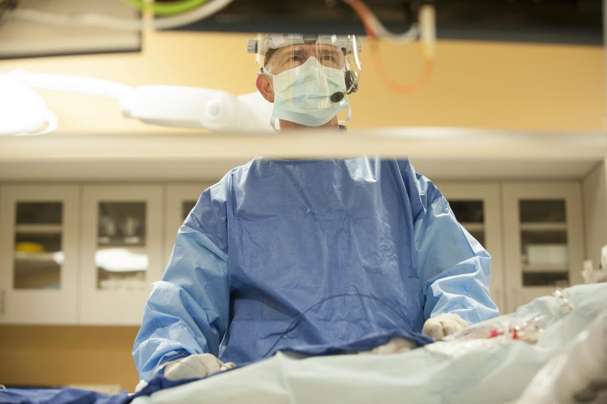 Cardiologist Dr. James Reiss uses monitors with 3-D imaging of a patient's heart to guide him during a cryoablation procedure March 2 at PeaceHealth Southwest Medical Center.