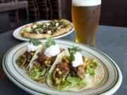 Pork carnitas tacos and the Electric Mayhem pizza are served June 9 at McMenamins East Vancouver.