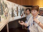 Keiko Toda examines a portion of the Fort Vancouver Tapestry that she helped stitch, which shows the history of Clark County.