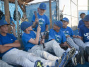 Ben Jones (2nd from left) and his teammates from the Cascade Little League look at a bat from the 2000 Little League World Series given to them by Jay Ponciano, who played on that Hazel Dell team.