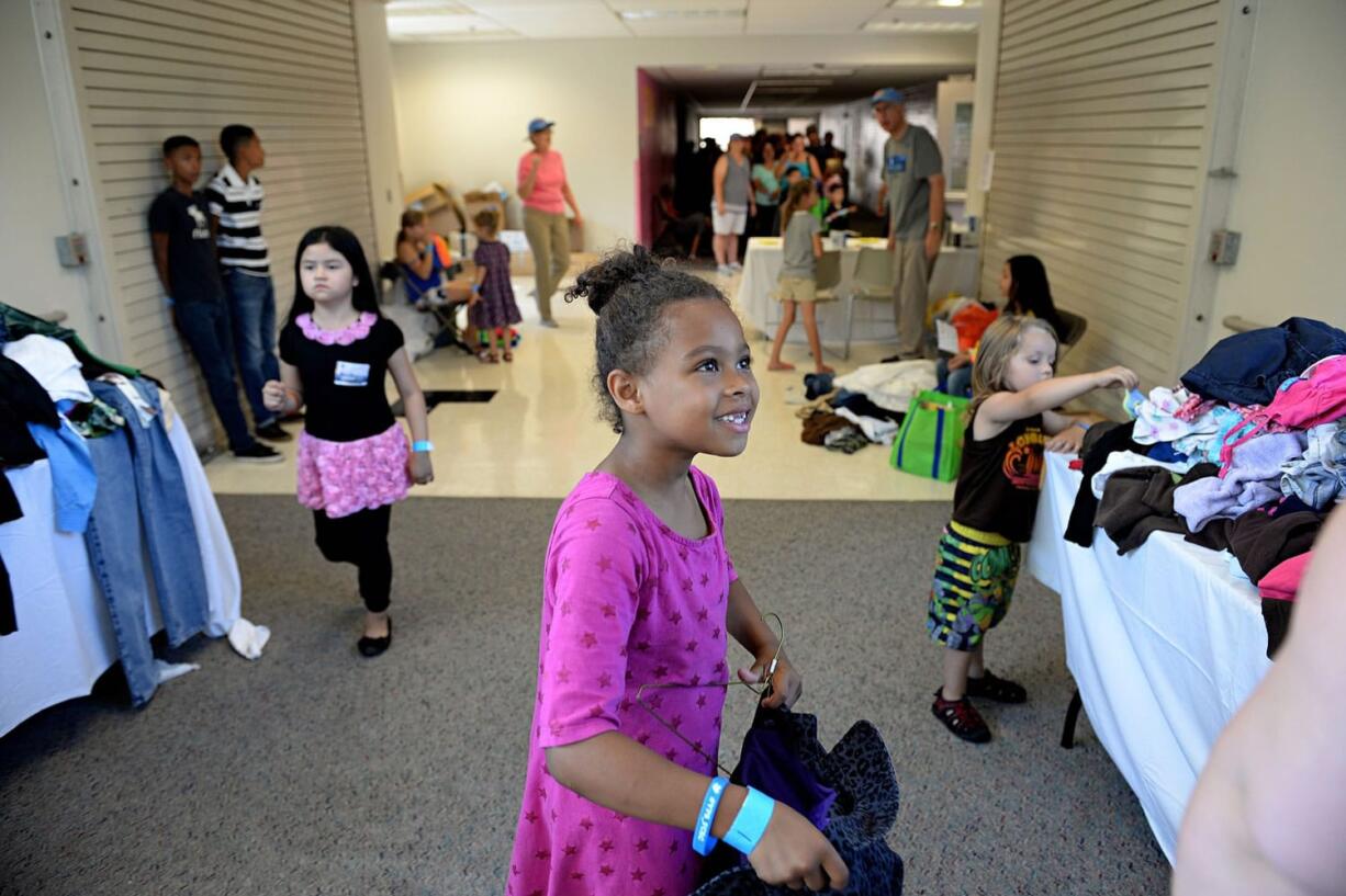 Photos by Amanda Cowan/The Columbian
Ryileigh Jones, 6, looks to her mother for approval while choosing clothing at the Go Ready Festival on Wednesday at Hudson's Bay High School. The festival provides immunizations, haircuts, clothing, shoes -- and ice cream -- to Vancouver students in need.