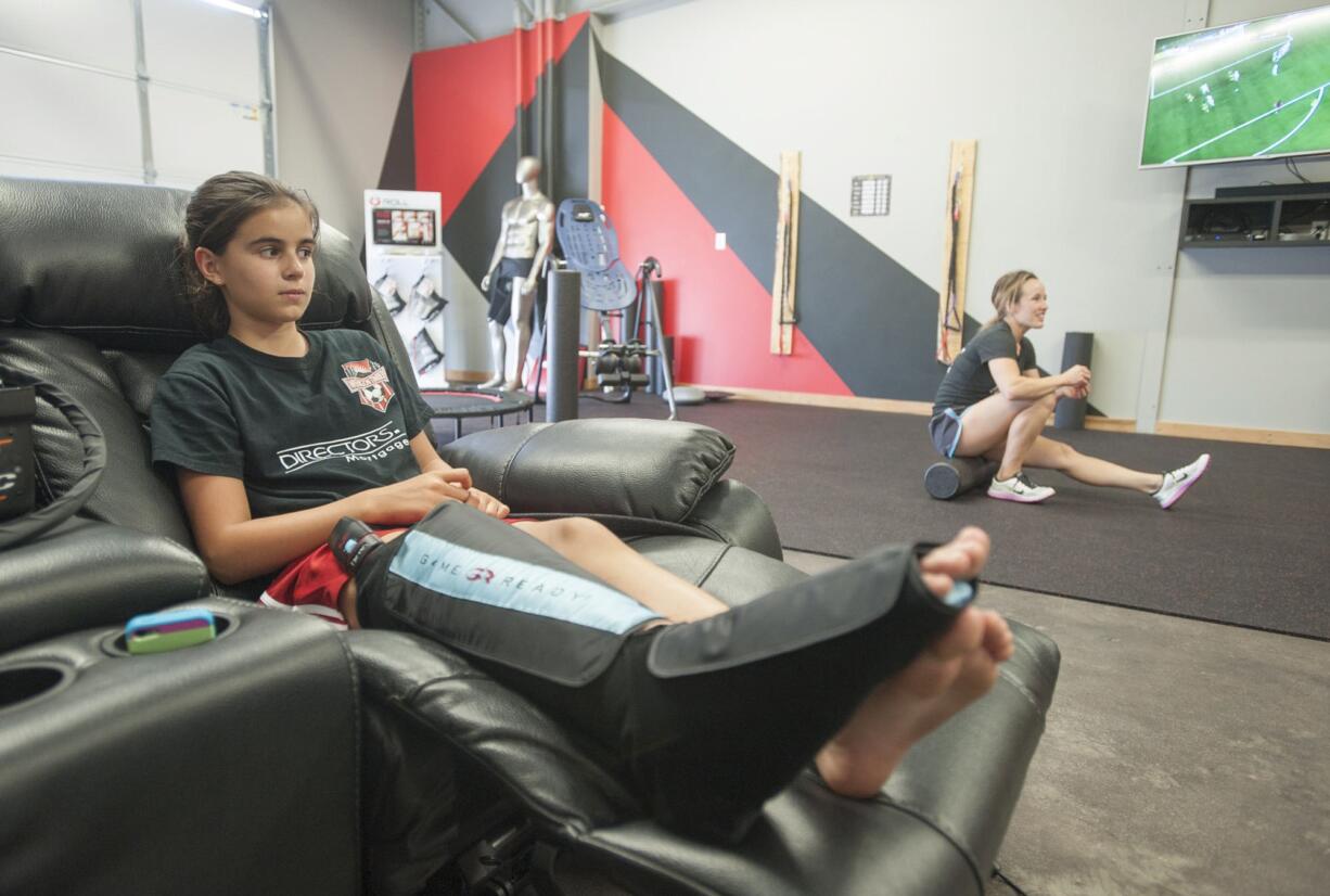 Soccer player Chloe White, 11, gets cold compression treatment on a sore Achilles tendon during a Wednesday visit to Recharge, a new athletic recovery lounge in Vancouver.