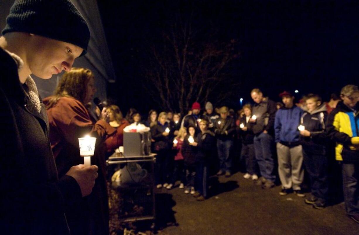 Devlin Stutts, 17, left, joins an estimated 300 people at a candlelight vigil for 14-year-old Cody Sherrell on Sunday night in La Center's Holley Park.