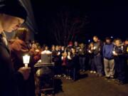 Devlin Stutts, 17, left, joins an estimated 300 people at a candlelight vigil for 14-year-old Cody Sherrell on Sunday night in La Center's Holley Park.