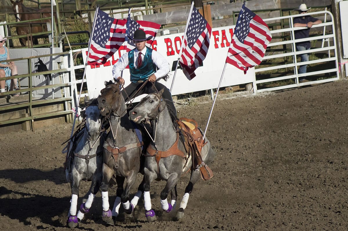 Kyzer Stoddard rides three horses during the Grand Entry on opening night at the Vancouver Rodeo.