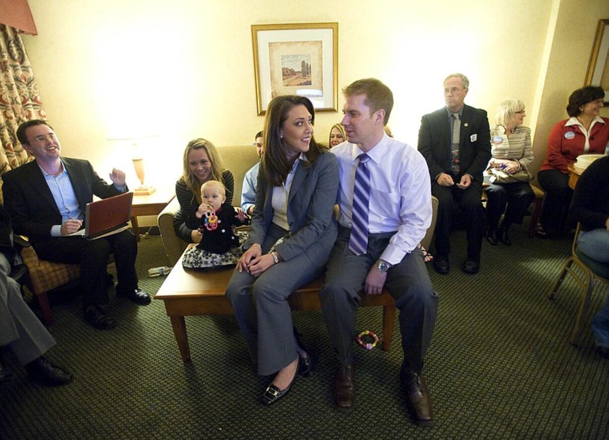 Jaime Herrera, center, watches results come in on the television with her husband Dan Beutler inside her room at the Red Lion Hotel Vancouver at the Quay on Tuesday. Herrera, a Republican won the race for the 3rd Congressional District.