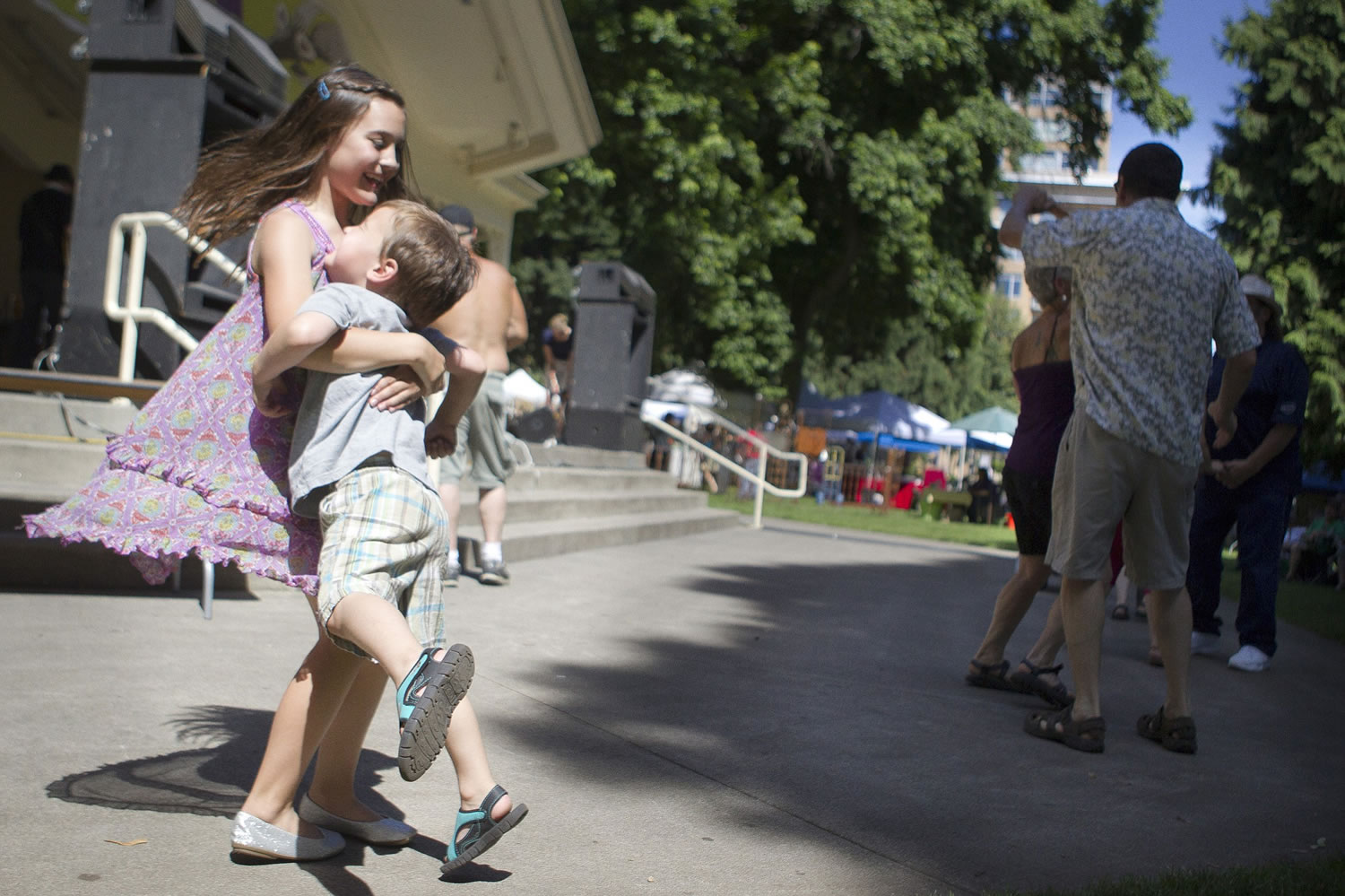 Grace Harvey, 9, swings her brother Ian, 4, around Saturday -- Grace's birthday -- as the two dance to a live band at the Recycled Arts Festival in Esther Short Park.