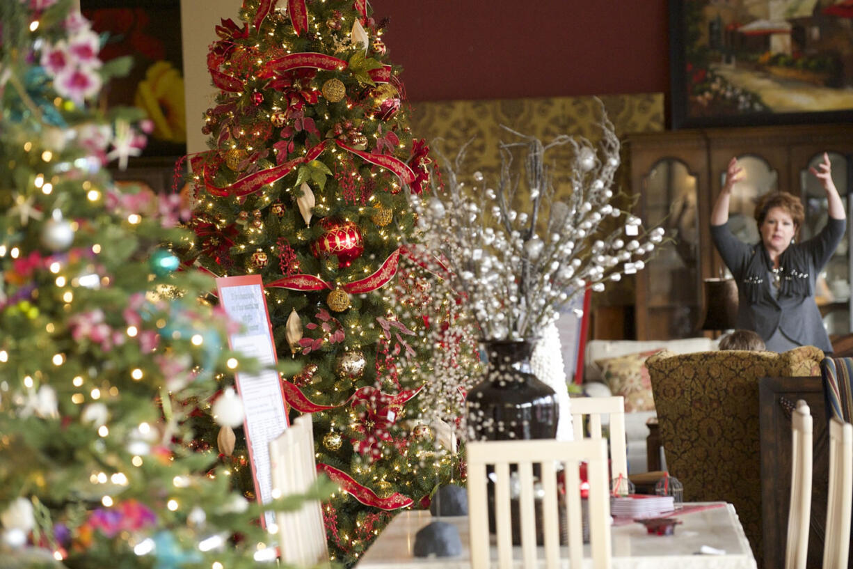 Robin Anderson's tree &quot;Memories are Made of This&quot; (with red bows and garlands) uses classics ornaments purchased at shows across the country.