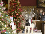 Robin Anderson's tree &quot;Memories are Made of This&quot; (with red bows and garlands) uses classics ornaments purchased at shows across the country.