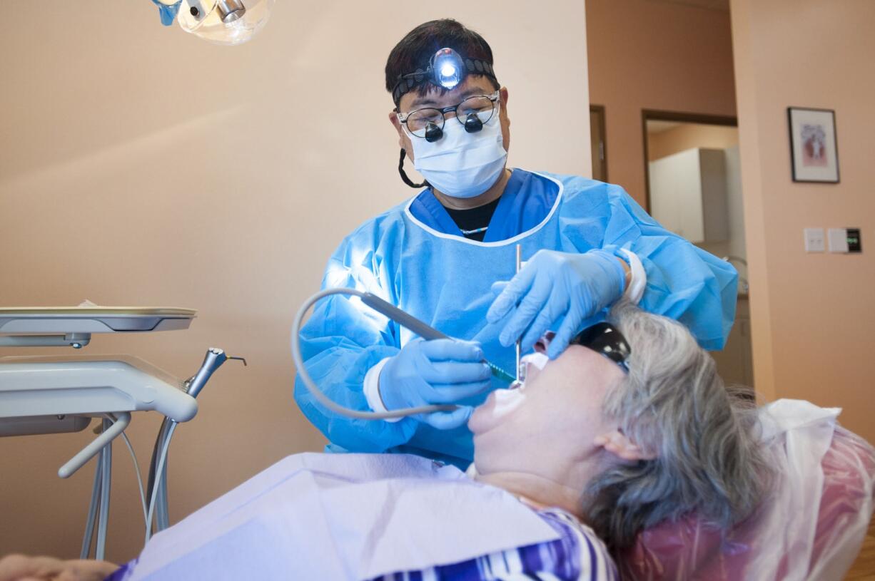 Dentist Steven Quan works on a patient Thursday morning at the new Geriatric Dental Group office in Vancouver.