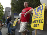 Brian Mitchell of Longview pickets outside the Riverview Bank building in downtown Vancouver, where United Grain has an office.