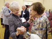 Photos by Steven Lane/The Columbian
Clark County First Citizen for 2014 Twyla Barnes, left, greets Maria Bigelow after her award ceremony at the Hilton Vancouver Washington on Tuesday. Barnes was noted for big-picture leadership while making every person she worked with feel special.