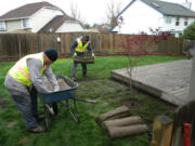 A crew with GRO Outdoor Living, a Vancouver landscaping company, repaired a piece of Mandy Hilkey's backyard Wednesday free of charge. Hilkey's husband, a staff sergeant with the Army National Guard, is scheduled to return home this weekend from his fourth tour overseas. Top: GRO also fixed a wooden fence.