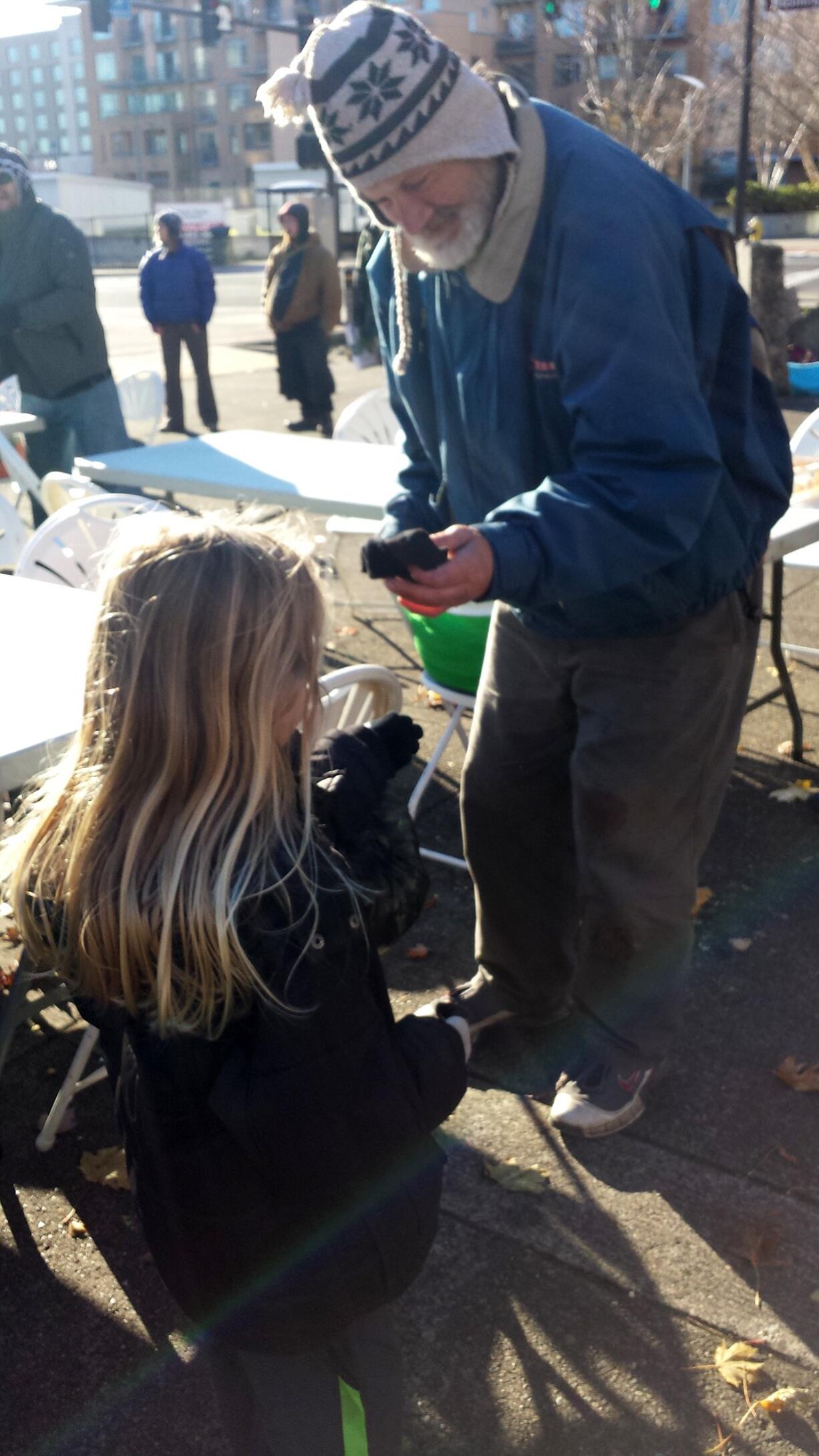 Esther Short: A 6-year-old girl hands out gloves to a homeless man during the Nov.