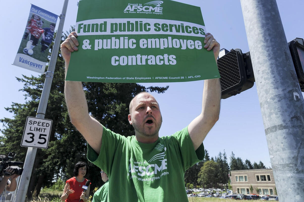 State employee Alex King rallies at the Department of Social and Health Services  in Vancouver on Thursday.