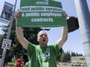 State employee Alex King rallies at the Department of Social and Health Services  in Vancouver on Thursday.