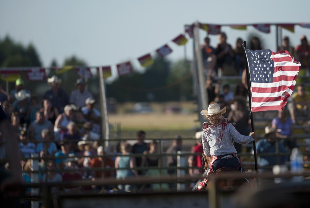 Zachary Kaufman/The Columbian files
A rider carries an American flag at the beginning of the Vancouver Rodeo at the Clark County Saddle Club in 2012.