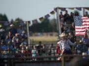 Zachary Kaufman/The Columbian files
A rider carries an American flag at the beginning of the Vancouver Rodeo at the Clark County Saddle Club in 2012.