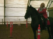 Susan McIntosh practices for the working equitation competition at Rob Zimmerman's South Ridge Farms ranch in Ridgefield.