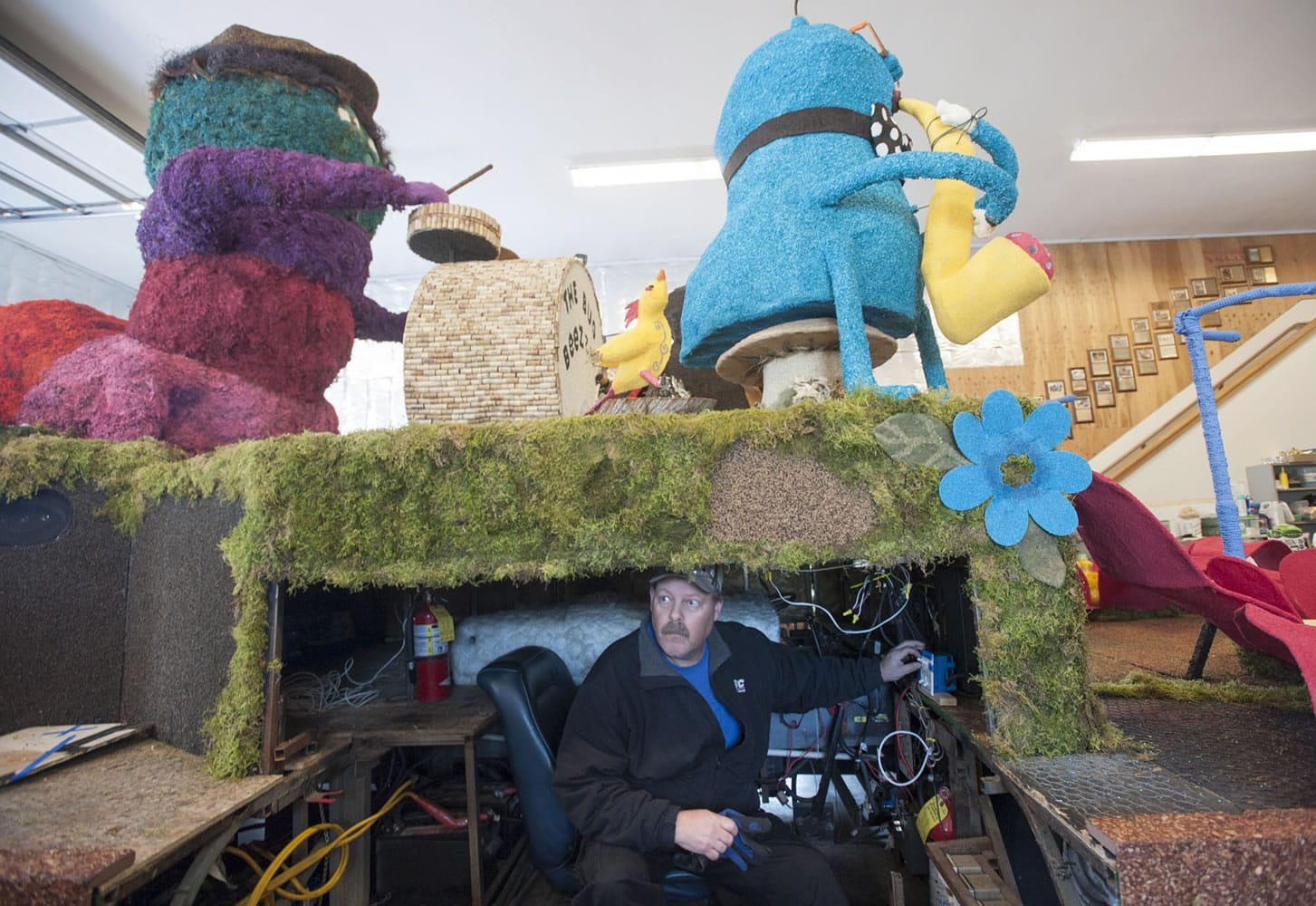 Fantasy and reality: Mike Burton, construction lead, demonstrates how he works magic from this hidden cockpit inside Battle Ground's parade float.