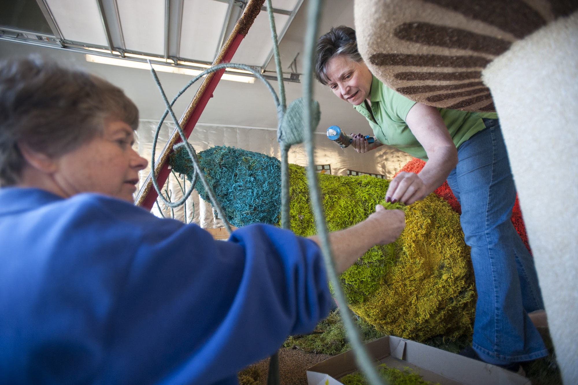 Decor co-chairwoman Pat Stanfield, left, hands decorative moss to co-chairwoman Barbara Garrison.