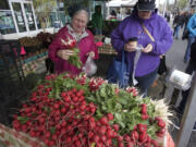 Photos by Steve Dipaola for the Columbian
Shoppers select fresh vegetables Saturday -- the second day of spring -- at the first Vancouver Farmers Market of 2015.