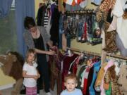 Visitors browse through hundreds of costume pieces that Camas resident Raina Kennedy offers through a free borrowing program out of her home.