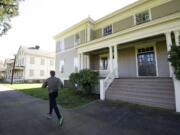 Photos by Steven Lane/The Columbian
The National Park Service has announced plans to renovate three &quot;front row&quot; barracks buildings at Fort Vancouver National Historic Site. A jogger Thursday goes past a smaller building, rehabbed in 2013, that shows what the other structures will look like.