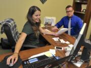 Kaydee Peterson, left, consults Wednesday with Ryan DesRochers in her office workspace in Vancouver.