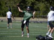 Camas High School's Liam Fitzgerald, center, throws to a teammate during practice Wednesday afternoon, August 19, 2015, at the school's practice field.