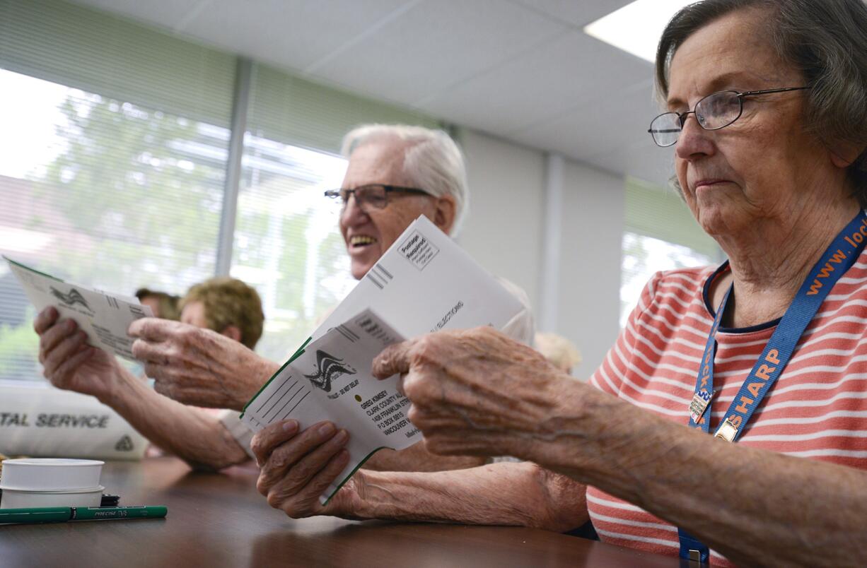 Ben Madsen, left, and Gurli Madsen inspect and sort ballots at the Clark County elections office on Wednesday.