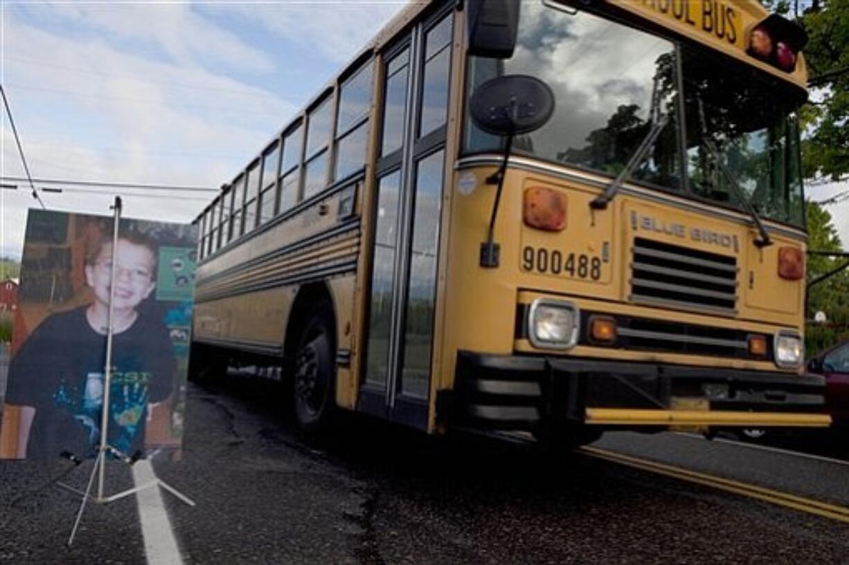 A school bus passes a picture prepared by the FBI showing missing student Kyron Horman as it drives up to Skyline School in Portland, Ore. on Monday, June 7, 2010.