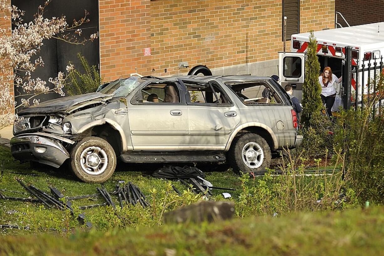 Alyssa Dawkins, 17, right, finishes checking on a friend in an ambulance after rolling her 1999 Ford Expedition several times after she said she swerved to avoid an oncoming car in her lane on Northwest 36th Avenue.